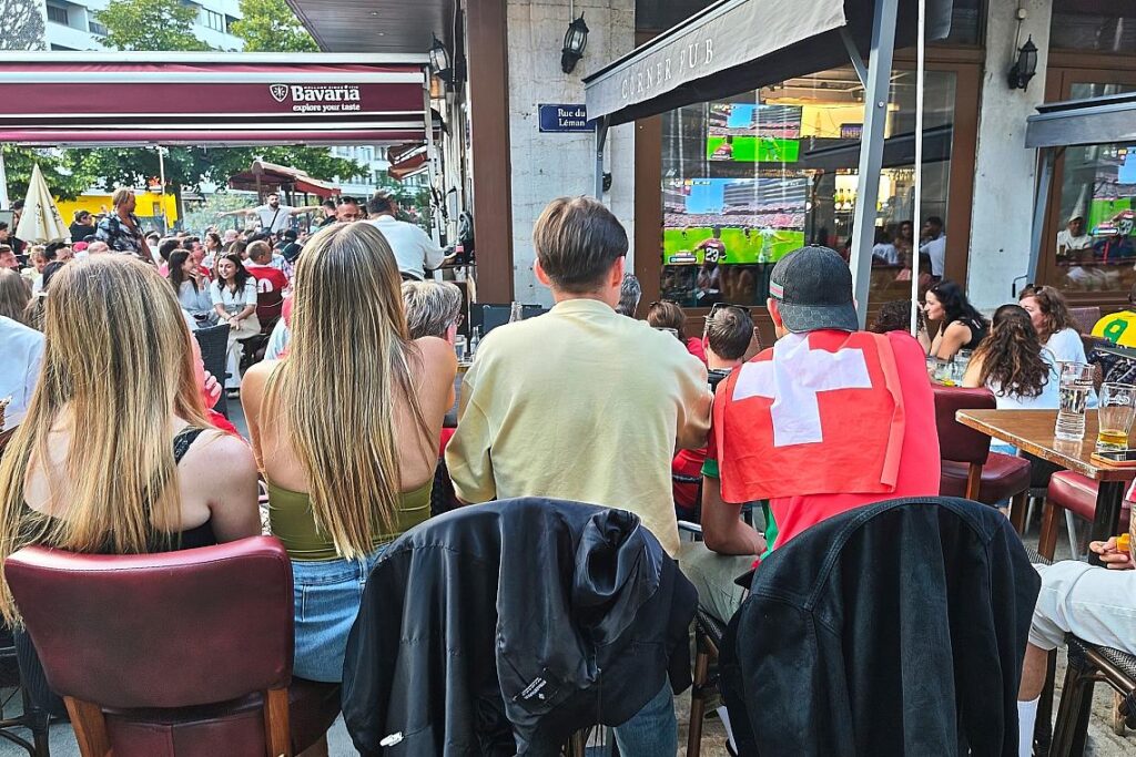 Fans und Interessierte schauen in einer Bar in Genf Fußball