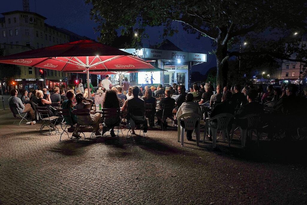 Interessierte schauen auf der Straße Fußball bei der WM 2026
